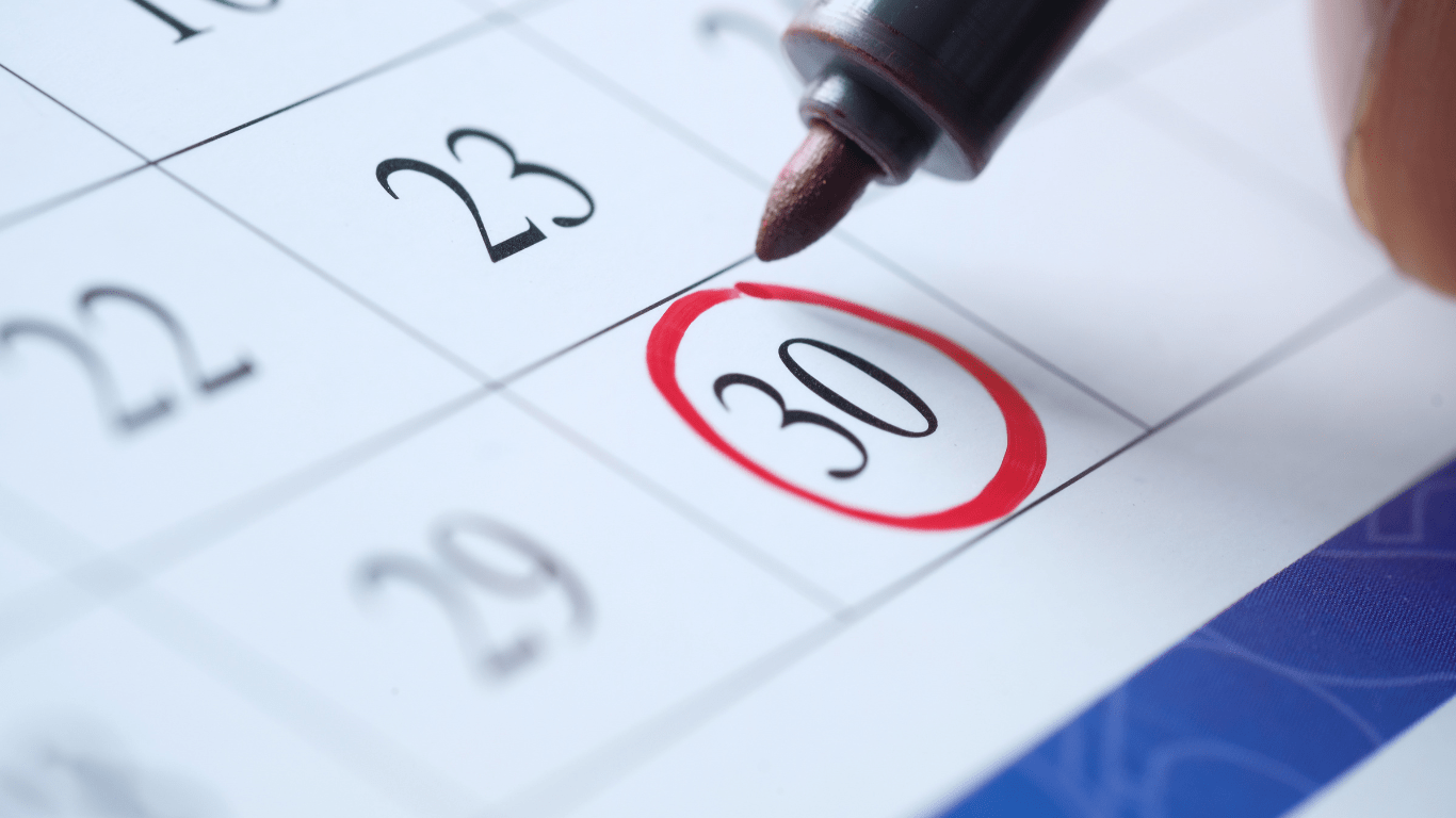 a close up of a hand writing on a calendar