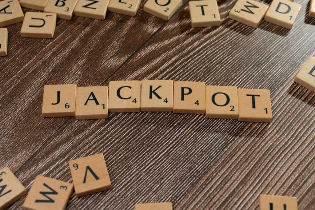 Wooden letter tiles spelling 'JACKPOT' on a textured wooden surface, representing winning or success.
